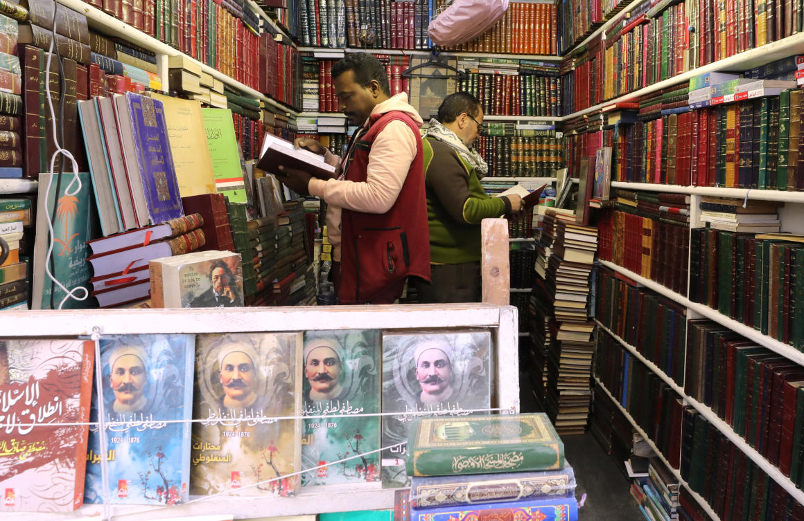 Two men check books at the Al-Azbakeya book market in Cairo, Egypt. (Reuters)