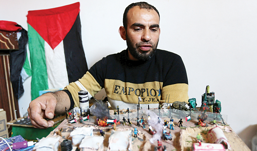 Palestinian diorama artist Majdi Abu Taqeya displays the miniature figures he carves from remnants of Israeli ammunition. (Reuters)