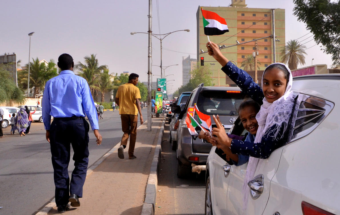Demonstrators wave their national flags as they drive along the streets of Sudan on April 11, 2019. (Reuters)