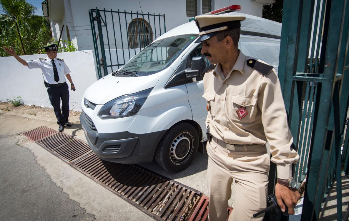 Members of the Moroccan security forces stand guard as a car transporting extremist suspects charged over the brutal murder of two Scandinavian women hiking in Morocco, drives backward to a court in Sale, near the capital Rabat on May 16, 2019. (AFP)