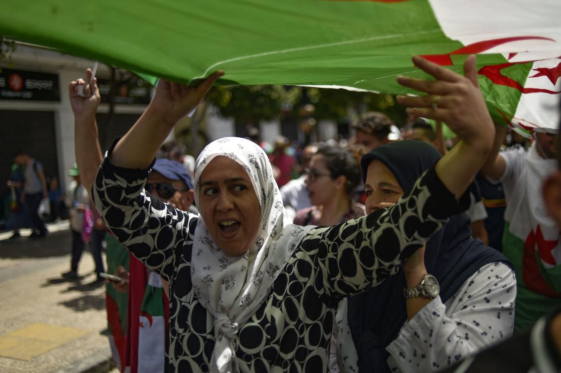 Algerians brandishing national flags take part in a weekly demonstration in the capital Algiers on June 14, 2019. (AFP)