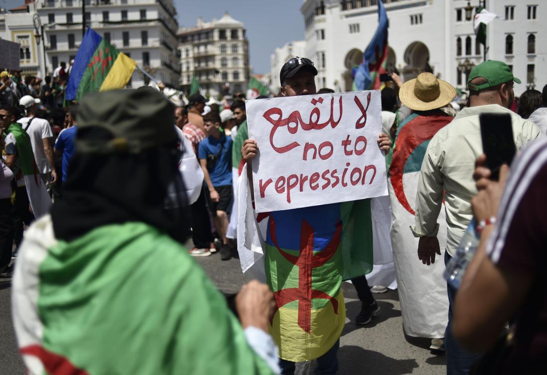 An Algerian man raises a placard as he takes part in a weekly demonstration in the capital Algiers on June 14, 2019. (AFP)