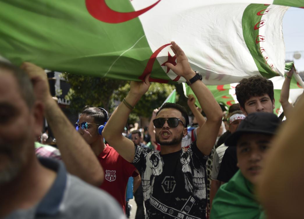 Algerians brandishing national flags take part in a weekly demonstration in the capital Algiers on June 14, 2019. (AFP)