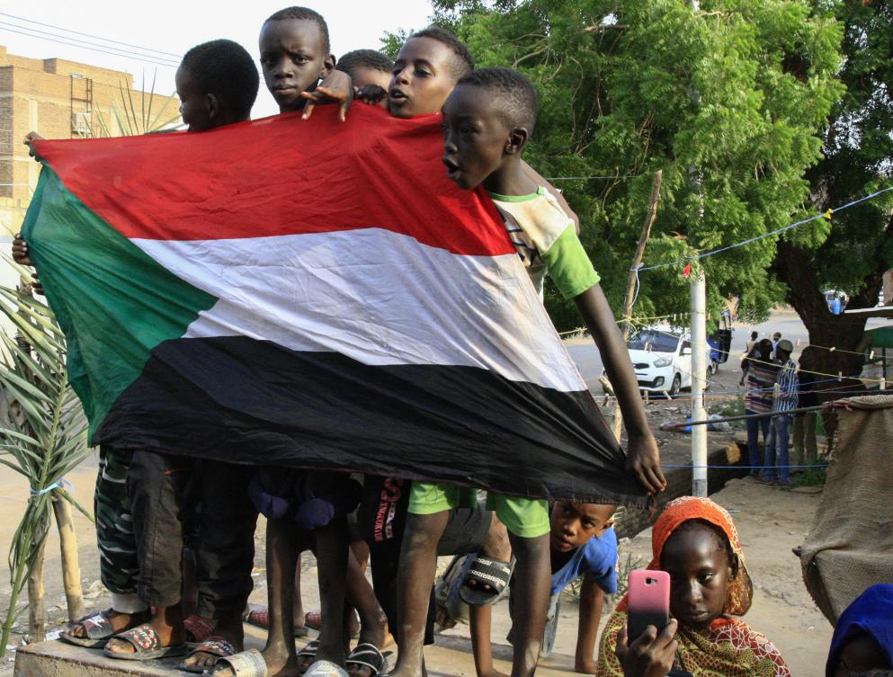 Young Sudanese boys carry a national flag as they celebrate in Bahri, the capital Khartoum's northern district, a day after generals and protest leaders signed a historic transitional constitution meant to pave the way for civilian rule in Sudan, on August 18, 2019. (AFP)