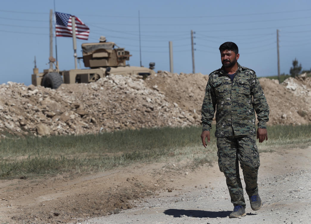 In this April 4, 2018 file photo, a US-backed Syrian Manbij Military Council soldier passes a U.S. position near the tense front line with Turkish-backed fighters, in Manbij, north Syria. (AP)