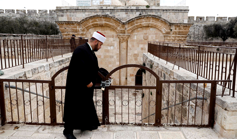 A cleric checks a gate at the Al-Aqsa Mosque compound in Jerusalem. (AFP)