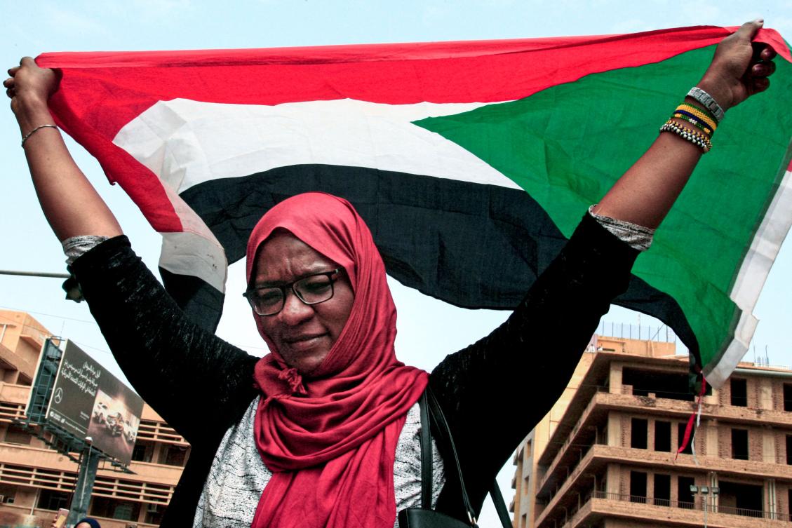 A woman waves a Sudanese national flag during a demonstration near the presidential palace in the capital Khartoum on September 12, 2019. (AFP)