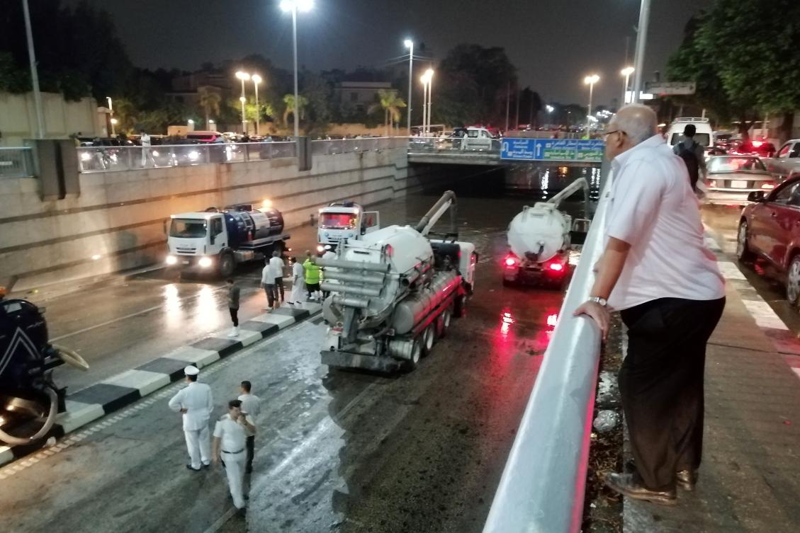 A man watches rescue vehicles withdrawing water by suction from the al-Oroba tunnel in the Heliopolis district after rain led to traffic jam in the Egyptian capital Cairo on October 22, 2019. (AFP)