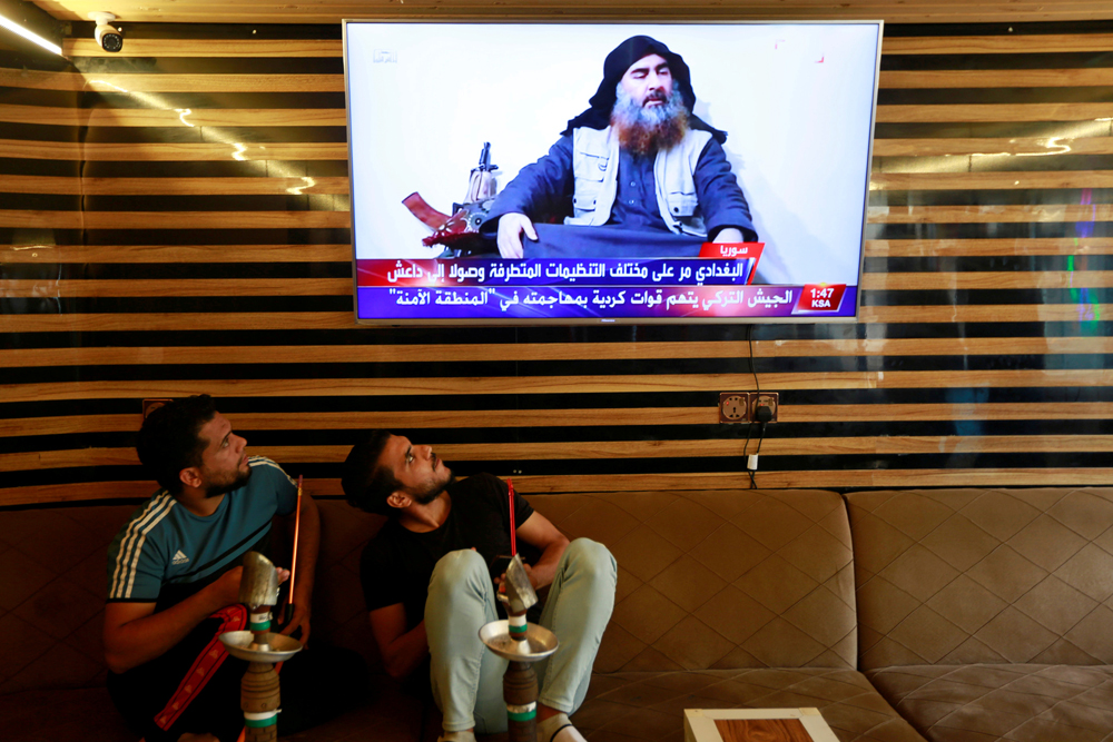 Iraqi youth watch the news of Daeshleader Abu Bakr al-Baghdadi death, in Najaf, Iraq, on October 27, 2019. (REUTERS/Alaa al-Marjani)