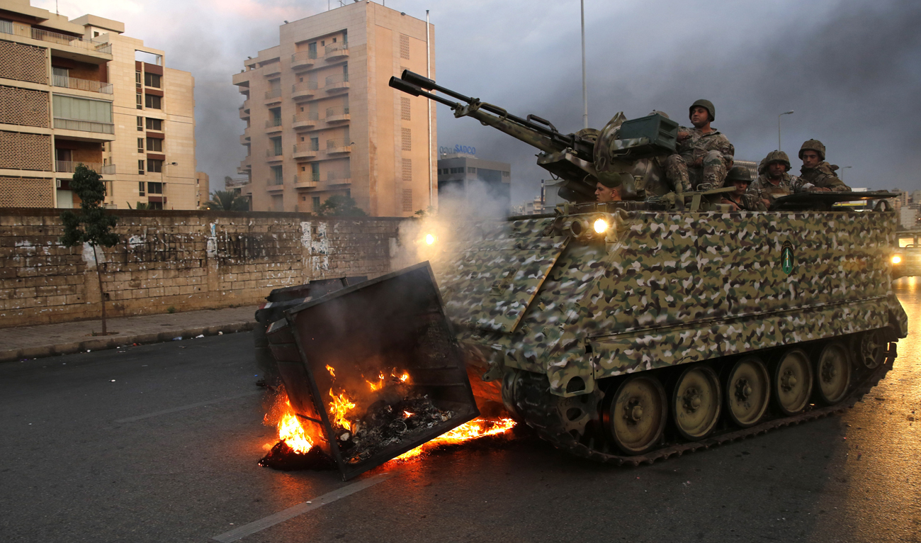 An army armored personnel carrier removes a garbage container set on fire by anti-government protesters in Beirut, Lebanon, Monday, Oct. 28, 2019. (AP)