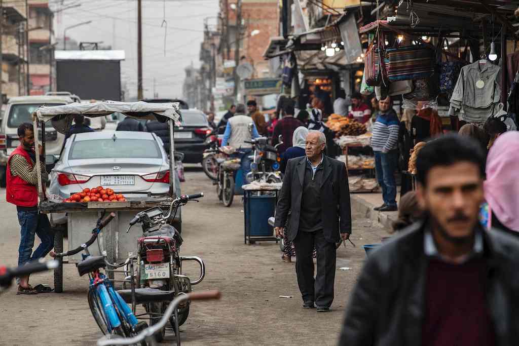 Syrians walk through a market in the Kurdish-majority city of Qamishli, in Syria's northeastern Hasakeh province, on October 29, 2019. (AFP)