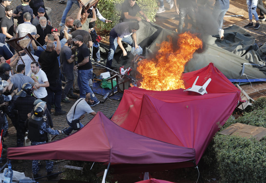 Hezbollah supporters burn tents in the protest camp set up by anti-government protesters near the government palace, in Beirut, Lebanon, Tuesday, Oct. 29, 2019. (AP)