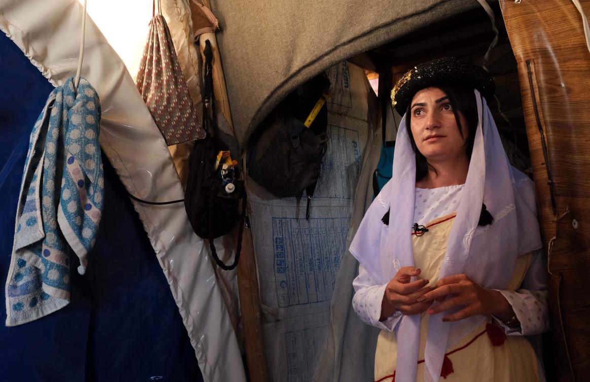 Iman Abbas, an 18-year-old Yazidi woman dressed in a traditional outfit, gazes at herself in a mirror inside a tent at the Shaira camp for displaced people in the Simele district of the Dohuk governorate in northern Iraq, on November 21, 2019. Abbas who was repeatedly sold as a