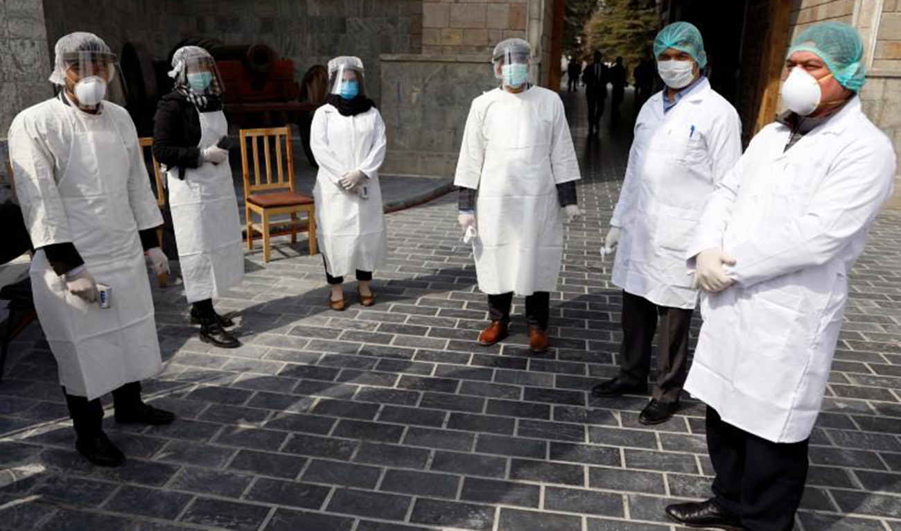 Afghan health workers in protective gears wait to check people in Kabul, Afghanistan. (Reuters)