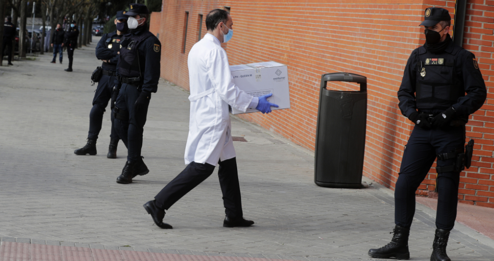 Police stand by the entrance of a nursing home as a box of some of the first Pfizer coronavirus vaccines arrives in Madrid. (AP)