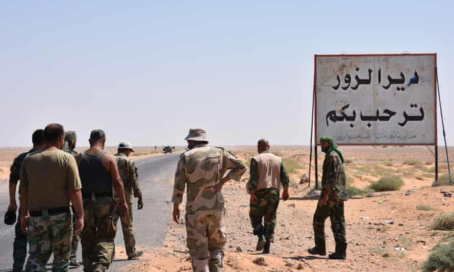 Syrian government troops stand beside a ‘Welcome to Deir Ezzor’ sign. (File/AFP)