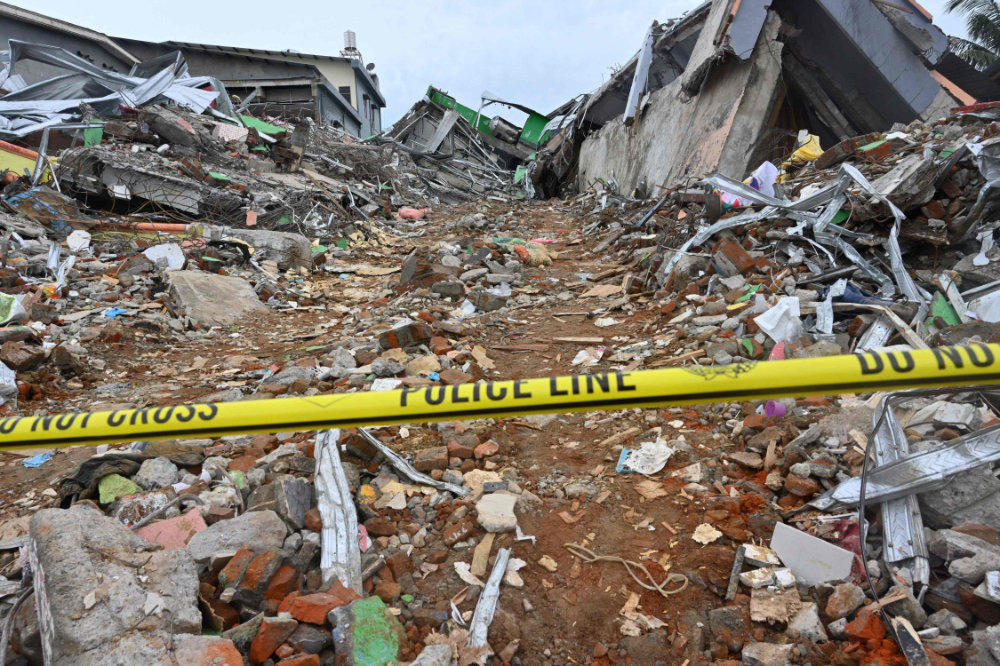 A police line is placed at a damaged building following a 6.2 magnitude earthquake in Mamuju, Indonesia, on January 17, 2021. (AFP / ADEK BERRY)