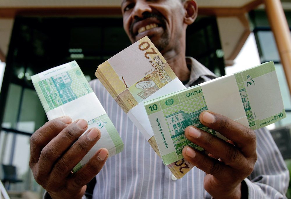 A Sudanese man shows freshly-minted notes of the new Sudanese pound in Khartoum. (File/AFP)