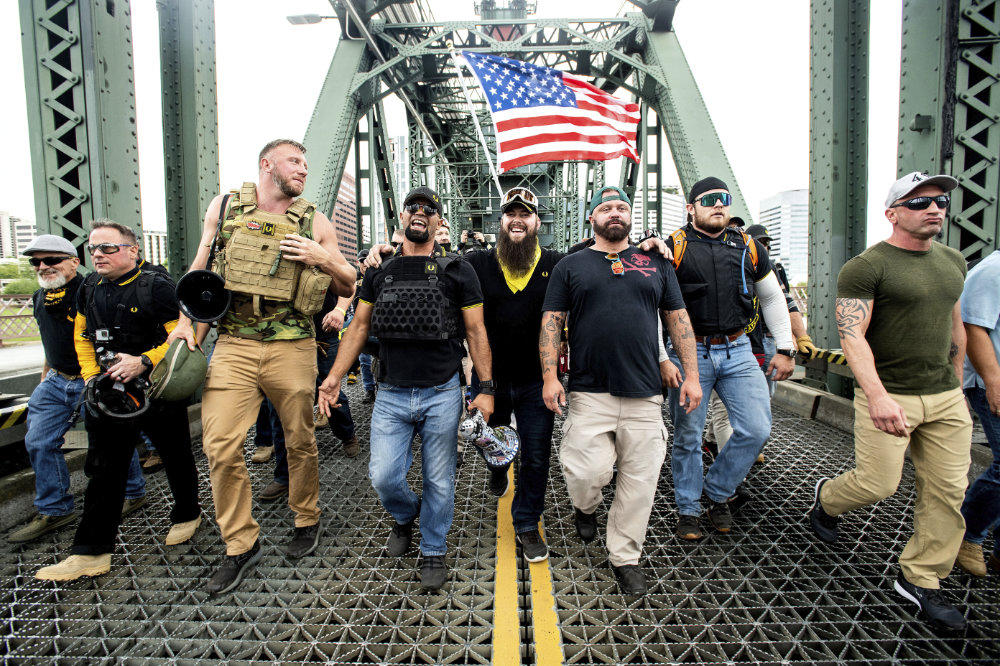 Members of the Proud Boys, including organizer Joe Biggs, third from right, march across the Hawthorne Bridge during an "End Domestic Terrorism" rally in Portland, Oregon, on Saturday, Aug. 17, 2019. Biggs was arrested Wednesday, Jan. 20, 2021 for taking part in the siege of the US Capitol earlier this month. (AP Photo/Noah Berger, file)