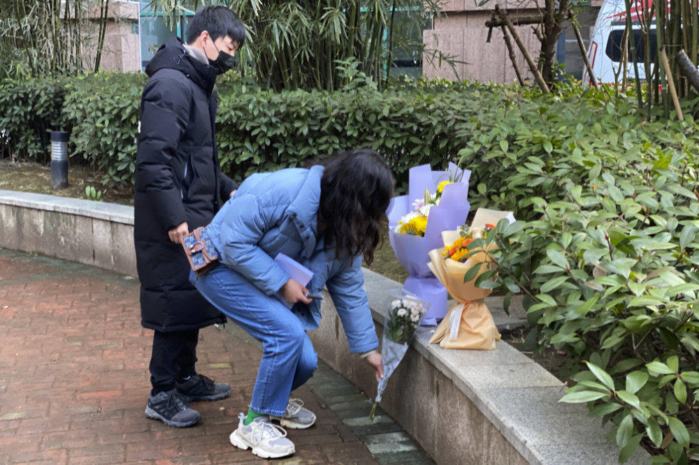 Residents visiting the Wuhan Central Hospital offer flowers in memory of  COVID-19 whistleblower Li Wenliang in central China's Hubei province on Feb. 6, 2021. (AP Photo/Ng Han Guan)