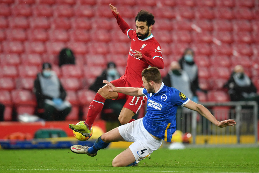 Brighton’s defender Adam Webster tackles Liverpool’s midfielder Mohamed Salah during a recent match in northwest England. (File/AFP)