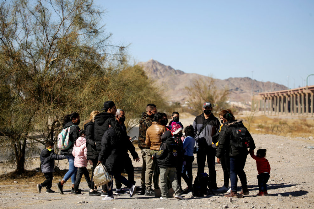Migrants stand near the Rio Bravo river in Ciudad Juarez, Mexico before crossing it to turn themselves in to request for asylum in El Paso, Texas on February 5, 2021. (REUTERS/Jose Luis Gonzalez/File Photo)