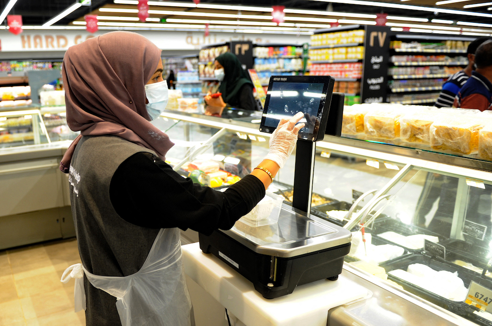 A Saudi female employee serves a customer at a hypermarket, newly launched by the operator LuLu and run by a team of women, in the Saudi Arabian port city of Jeddah, on Feb. 21, 2021. (AFP)