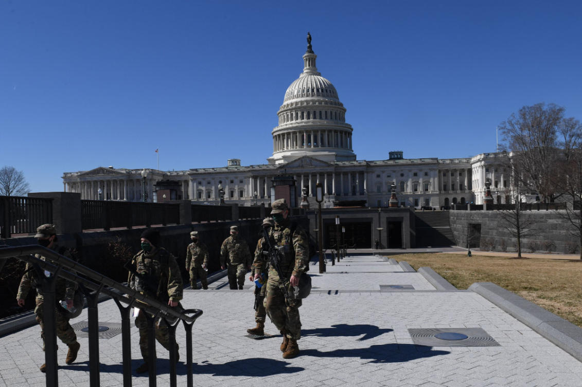 National Guard troops walk near the US Capitol Building in Washington, DC, on March 3, 2021 as security was bolstered after intelligence uncovered a "possible plot to breach the Capitol" on March 4. (AFP / Eric Baradat)