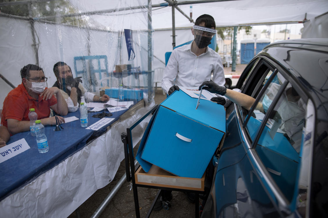 A women votes for Israel's parliamentary election at a special drive-in polling station for people who are in quarantine for coronavirus, in Ramat Gan, Israel. (AP)