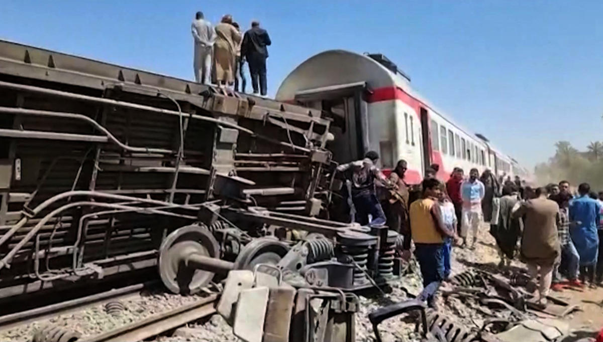 People gather around the wreckage of two trains that collided in the Tahta district of Sohag province, some 460 kms (285 miles) south of the Egyptian capital Cairo, on March 26, 2021. (AFP)