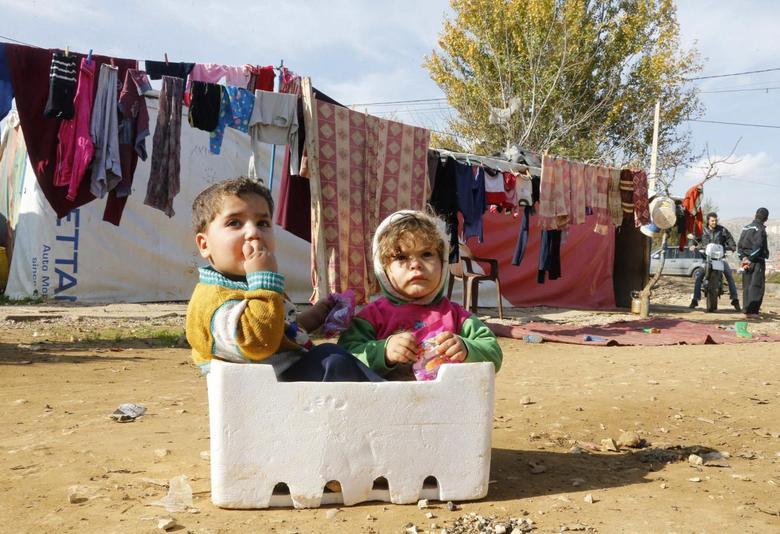 Syrian refugee children sit in a box at a makeshift settlement in Qab Elias in the Bekaa valley, Lebanon, December 8, 2014. (Reuters)