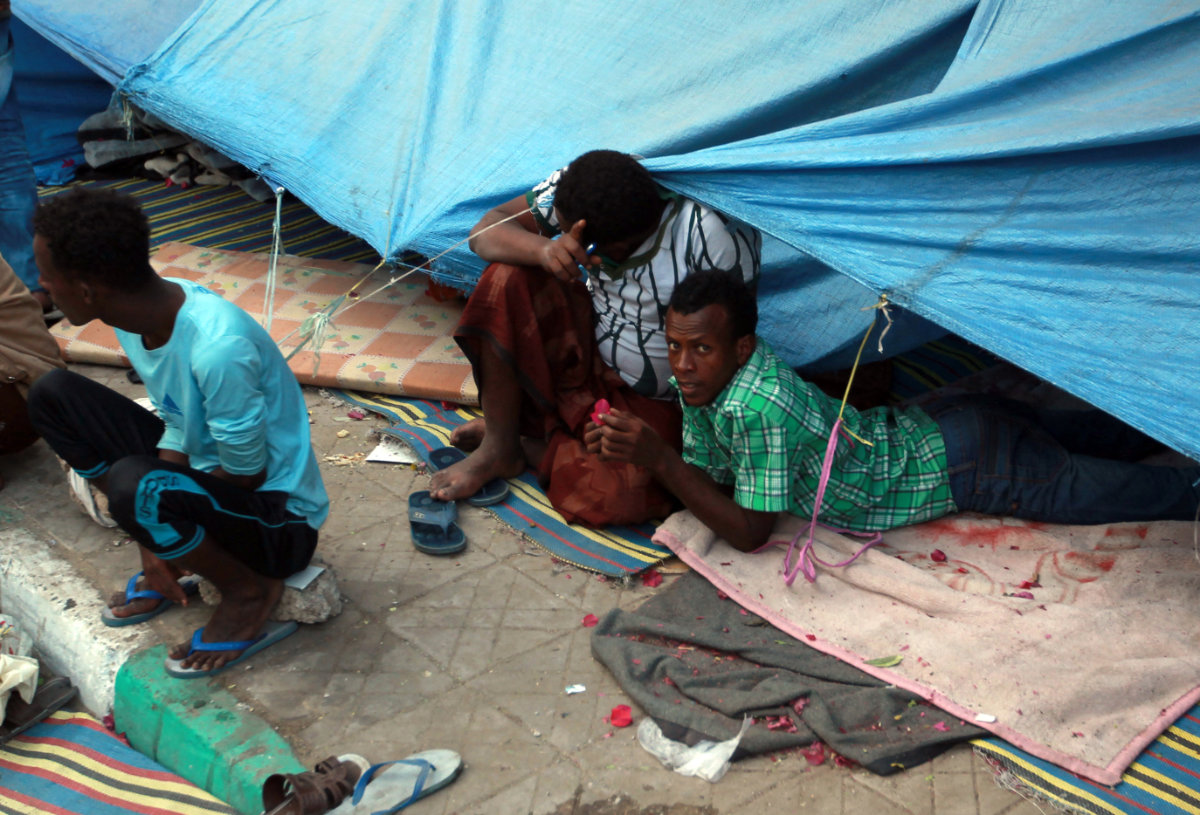  African migrants lay on the ground under a tarpaulin at a makeshift shelter on June 19, 2014, in Sanaa. (AFP file photo)