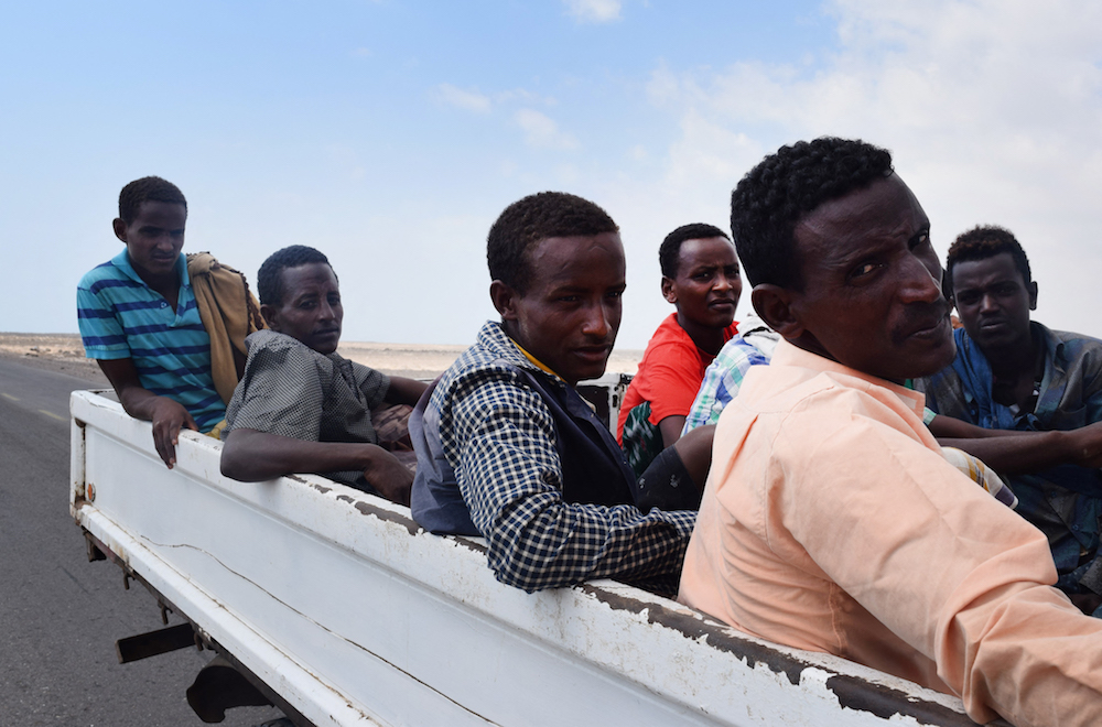 African migrants who were reportedly smuggled by sea into Yemen, sit on the back of a vehicle on the outskirts of the city of Aden. (AFP/File Photo)