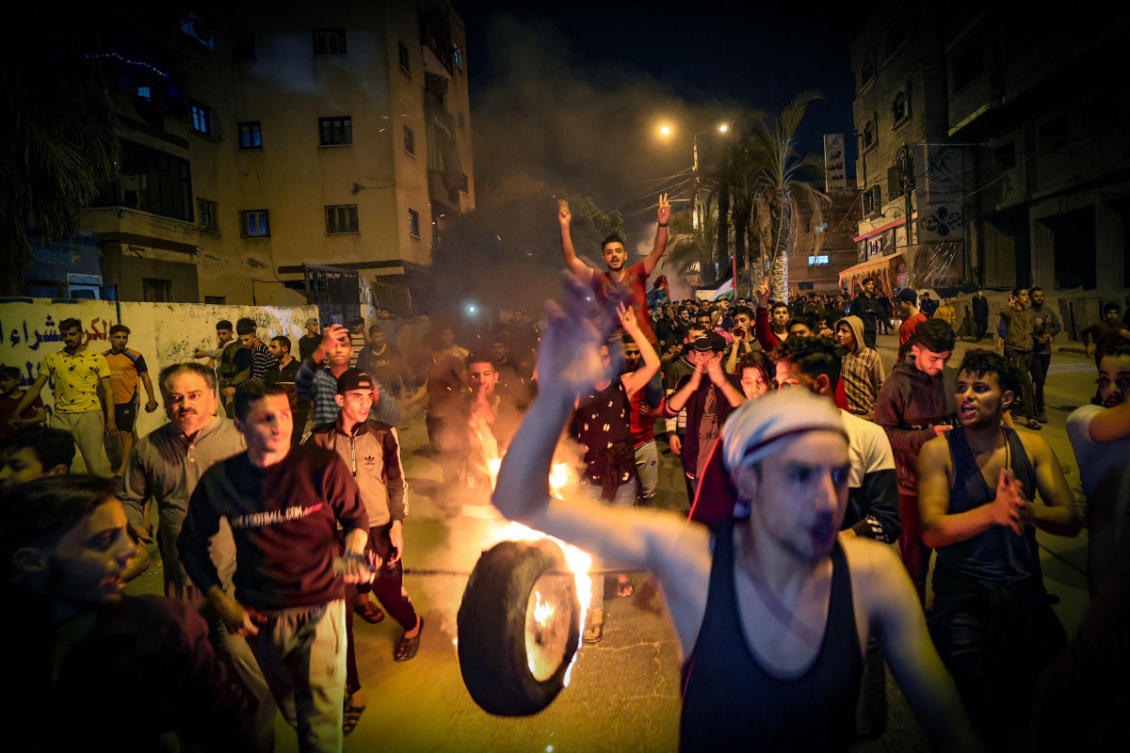 Palestinians parade a burning tire as they shout slogans in support of the Al-Aqsa Mosque during a rally in Gaza city on April 24, 2021, condemning overnight clashes in Israeli-annexed east Jerusalem. (AFP / Mohammed Abed)