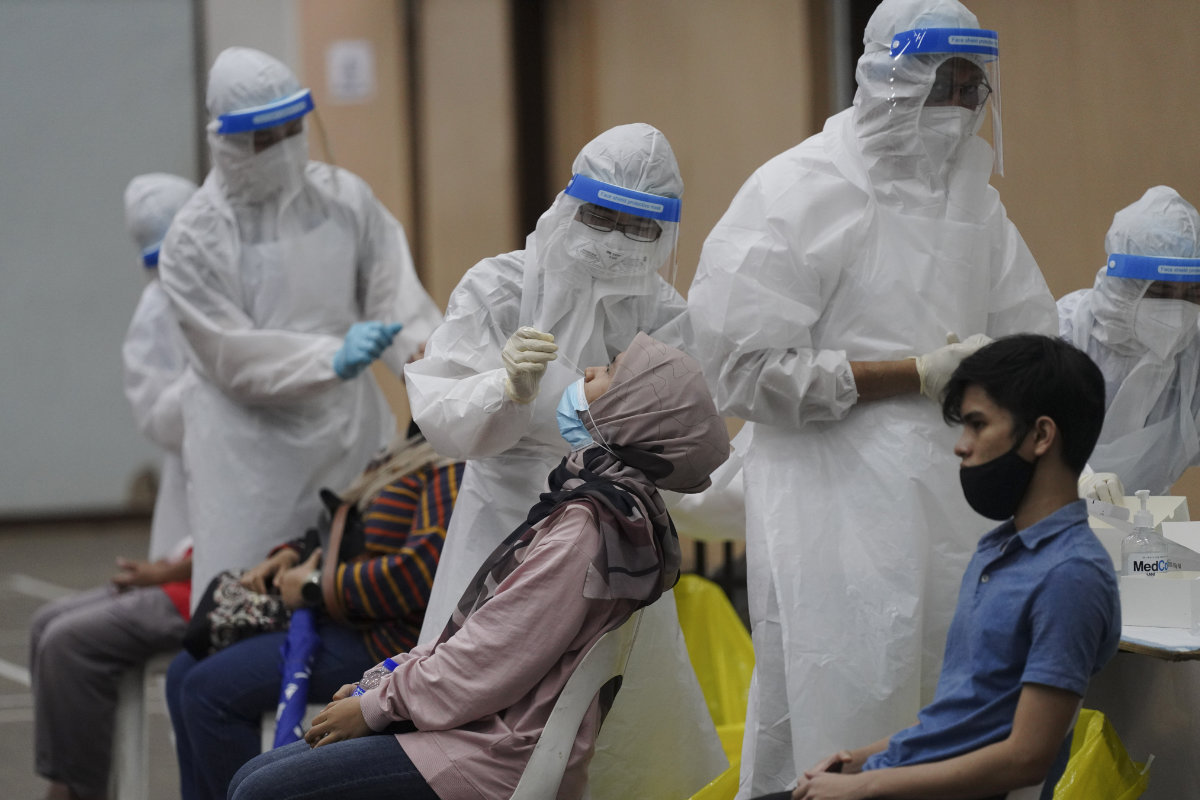 Medical workers collect swab samples from people during coronavirus testing at a COVID-19 testing center in Ulu Klang, on the outskirts of Kuala Lumpur, Malaysia, on May 18, 2021. (AP Photo/Vincent Thian) 