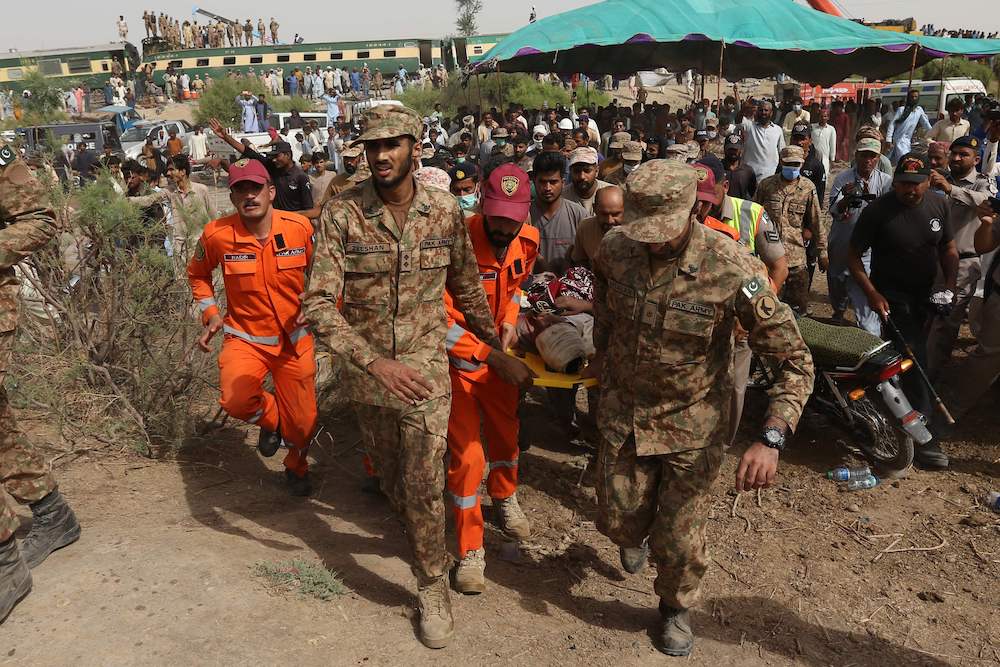 Security personnel carry an injured passenger to an army helicopter at the site of a train accident in Daharki area of the northern Sindh province on June 7, 2021. (AFP) Security personnel carry an injured passenger to an army helicopter at the site of a train accident in Daharki area of the northern Sindh province on June 7, 2021. (AFP)