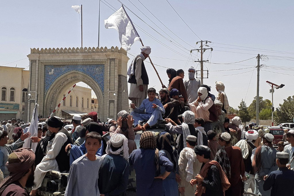 Victorious Taliban fighters mingle with villagers at a town in Kandahar on August 13, 2021. (AFP)