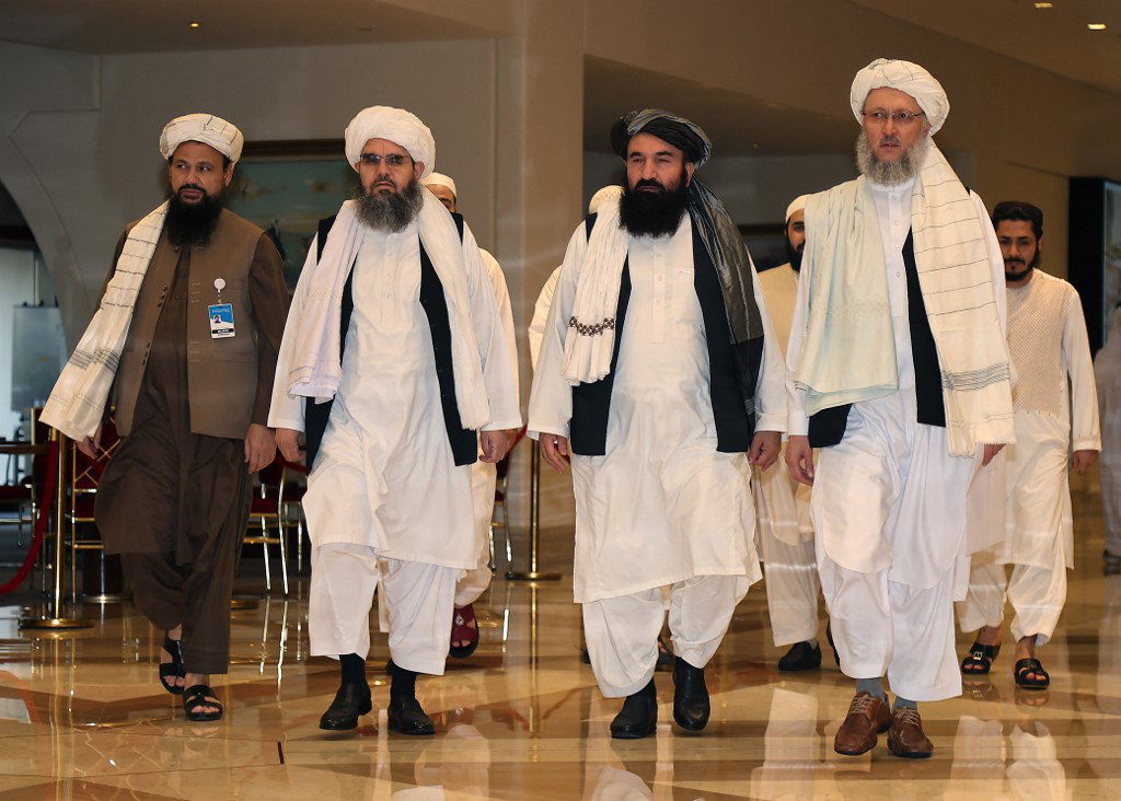 Taliban negotiators walk down a hotel lobby during the talks in Qatar's capital Doha on August 12, 2021. (KARIM JAAFAR / AFP)