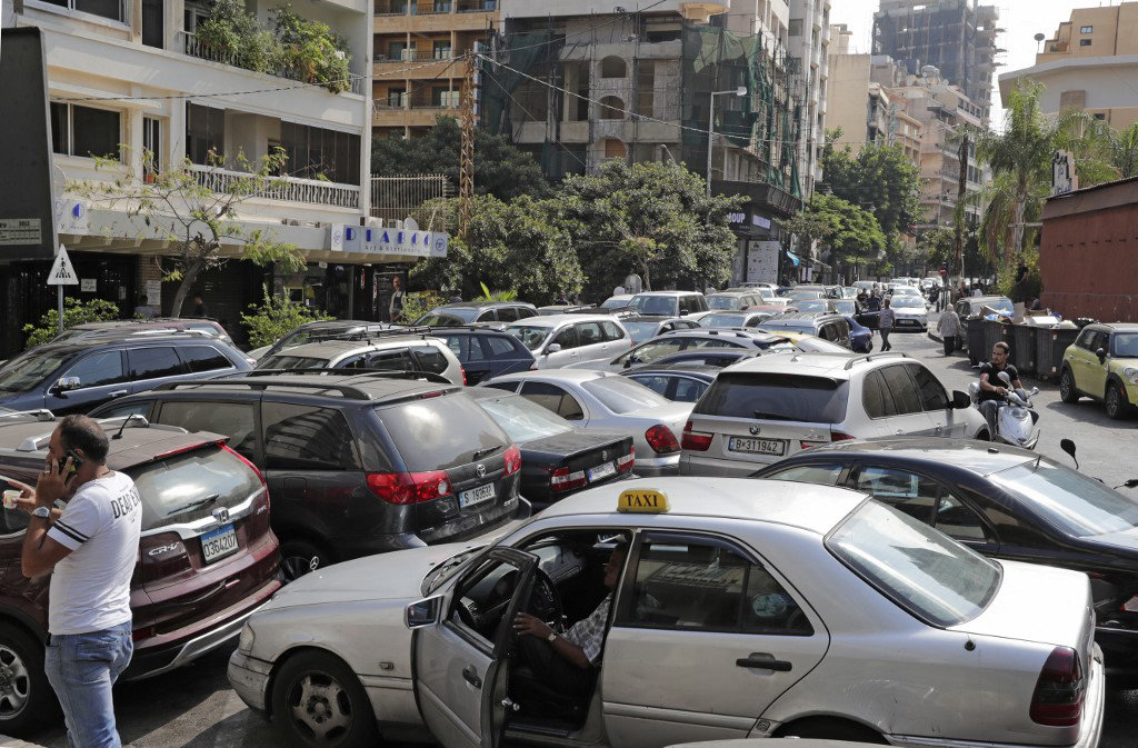 Lebanese wait in desperation outside a closed petrol station in Beirut's Hamra district on August 20, 2021. (AFP)