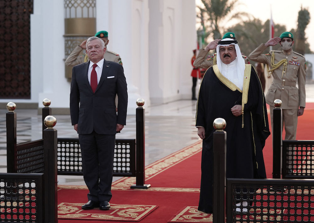 Jordan’s King Abdullah II (L) is received by Bahrain’s King Hamad upon his arrival at the Sakhir Air Base on Nov. 22, 2021. (Jordanian Royal Palace/Yousef Allan/AFP)
