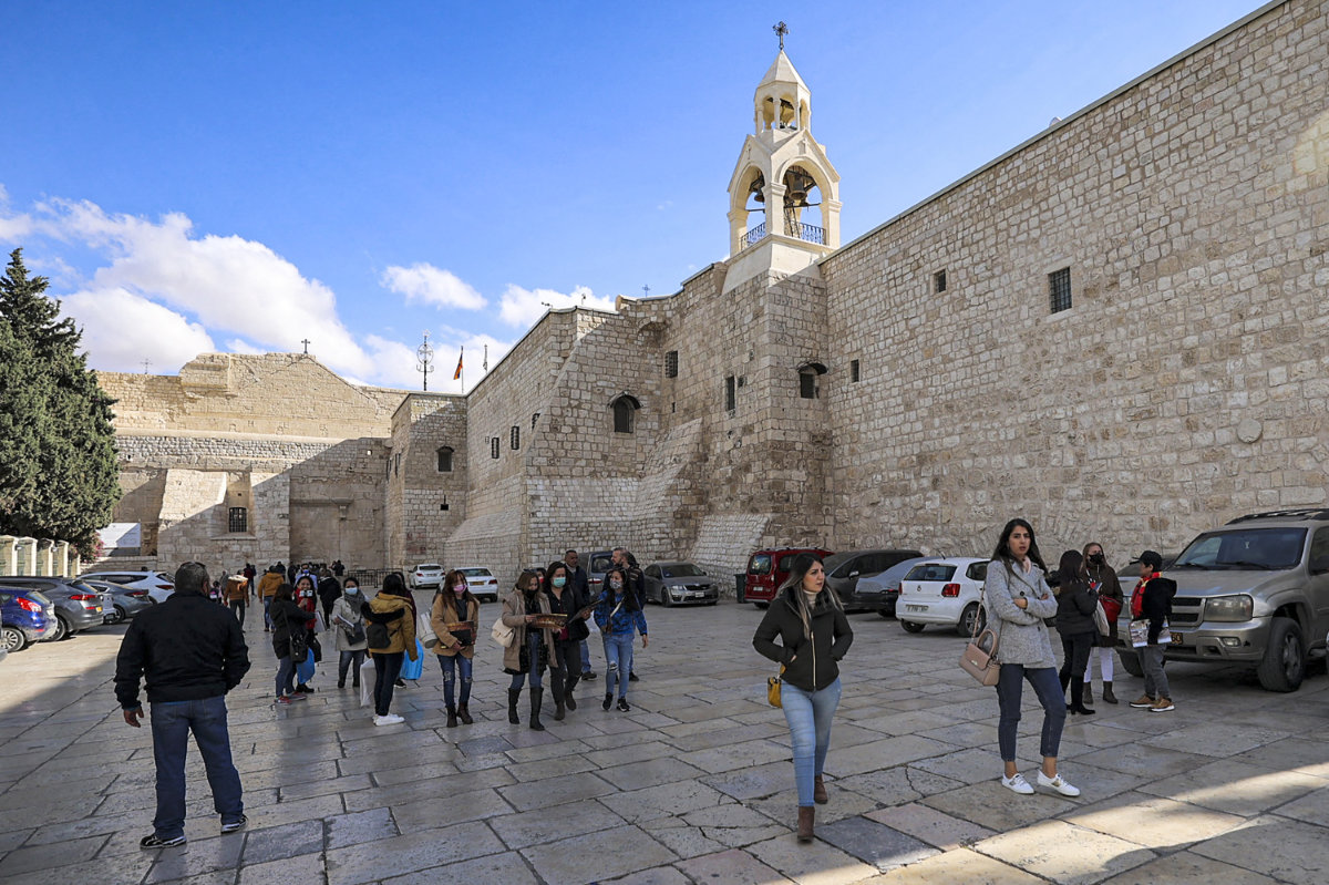 Christian worshippers walk outside the Church of the Nativity ahead of Christmas the biblical city of Bethlehem on Dec. 19, 2021. (AFP
