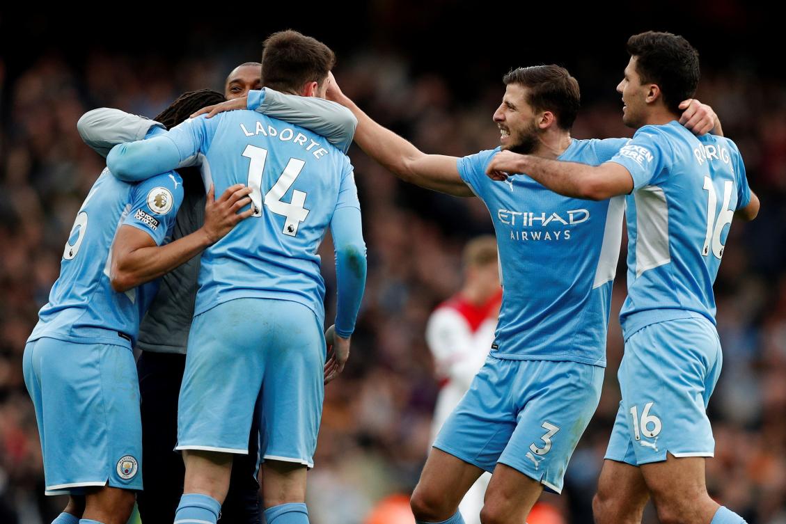 Manchester City's Spanish midfielder Rodri (R) celebrates with Manchester City's Portuguese defender Ruben Dias (2R) and teammates after the English Premier League football match between Arsenal and Manchester City at the Emirates Stadium. (AFP)