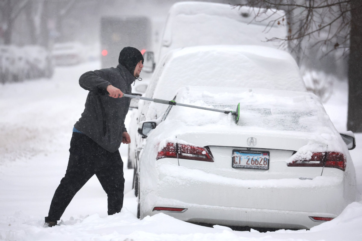 A man clears snow from his car on Feb. 2, 2022 in Chicago, Illinois, amid a massive storm working its way across the US Midwest. (Scott Olson/Getty Images/AFP)