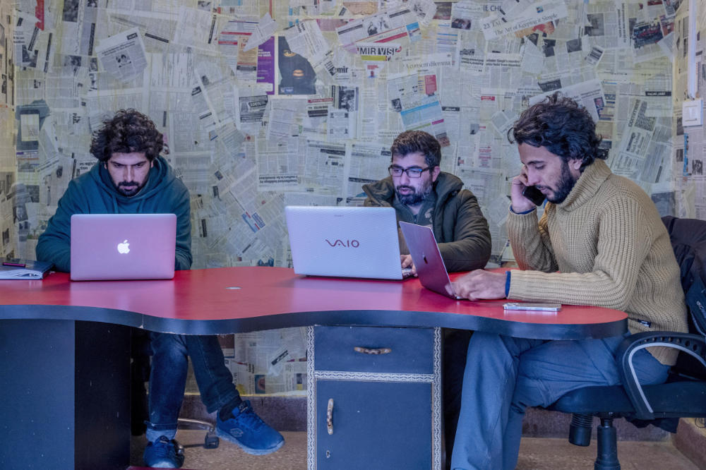 Fahad Shah, right, editor-in-chief of Kashmir Walla, works on his computer inside the newsroom at his office in Srinagar, Indian controlled Kashmir, Friday, Jan. 21, 2022. (AP)