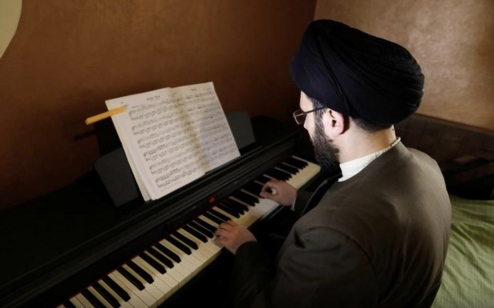 Muslim scholar Sayed Hussein Al-Husseini at the piano at his home in Dahieh, Beirut in 2018. (Reuters/File Photo)