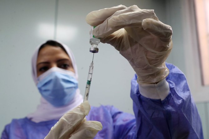 A healthcare worker holds a syringe and vaccine vial against the coronavirus disease (COVID-19) in Cairo last year. (Reuters/File Photo)