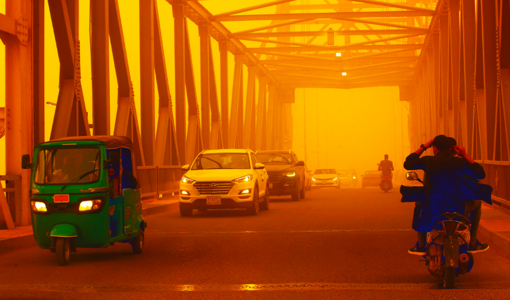 People navigate a street during a recent sandstorm in Basra, Iraq. Sandstorms have affected a total of 150 countries, adversely impacting on the environment. (AP)