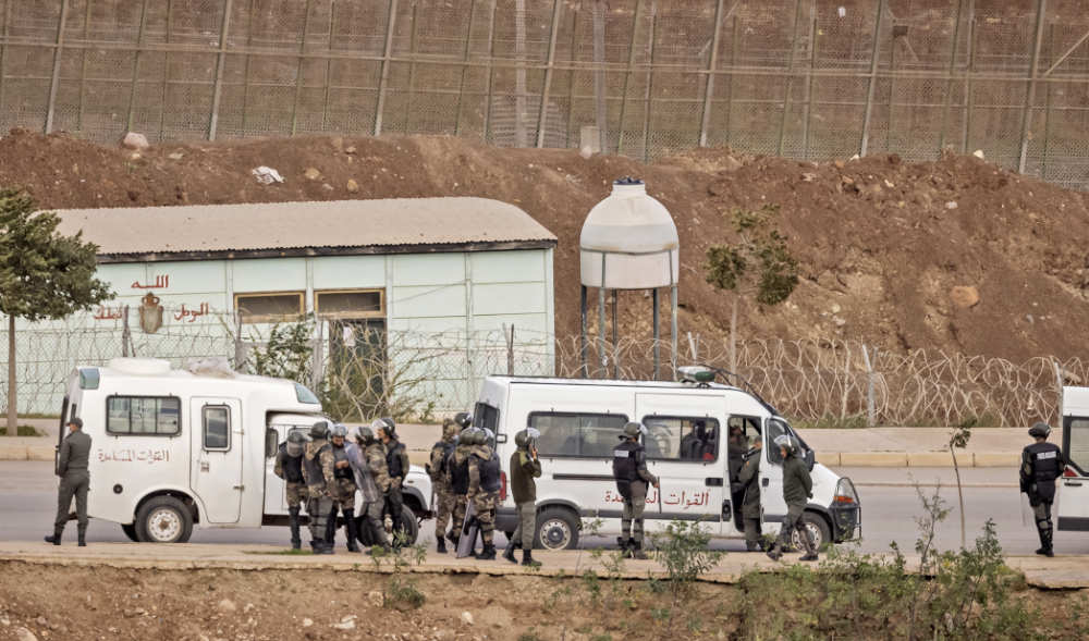 Paramilitaries of the Moroccan Auxiliary Forces stand guard by the border fence separating Morocco from Spain's North African Melilla enclave on March 4, 2022. (AFP) Paramilitaries of the Moroccan Auxiliary Forces stand guard by the border fence separating Morocco from Spain's North African Melilla enclave on March 4, 2022. (AFP)