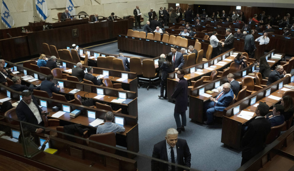 Israeli lawmaker Yair Lapid, foreground, walks the floor of Israel's parliament, the Knesset, as lawmakers convene for a vote on a contentious plan to overhaul the country's legal system, in Jerusalem, Monday, Feb. 20, 2023. (AP)