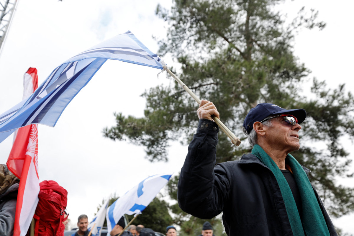 Ilan Margalit, a 69-year-old former fighter pilot, holds an Israeli flag at a demonstration in Jerusalem on February 9, 2023, by military reservists against proposed judicial changes by Israel's new right-wing government. (REUTERS)